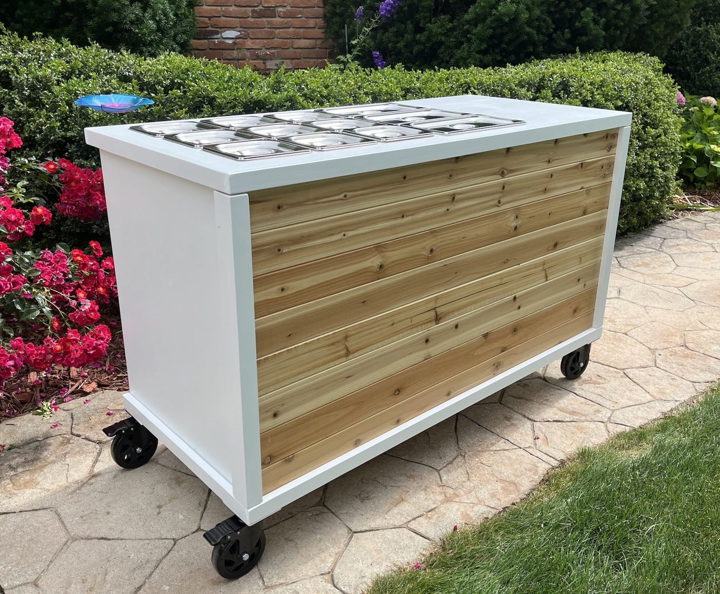 Charcuterie and grazing cart with a cedar wood panel, a clean white top and a full row of stainless wells